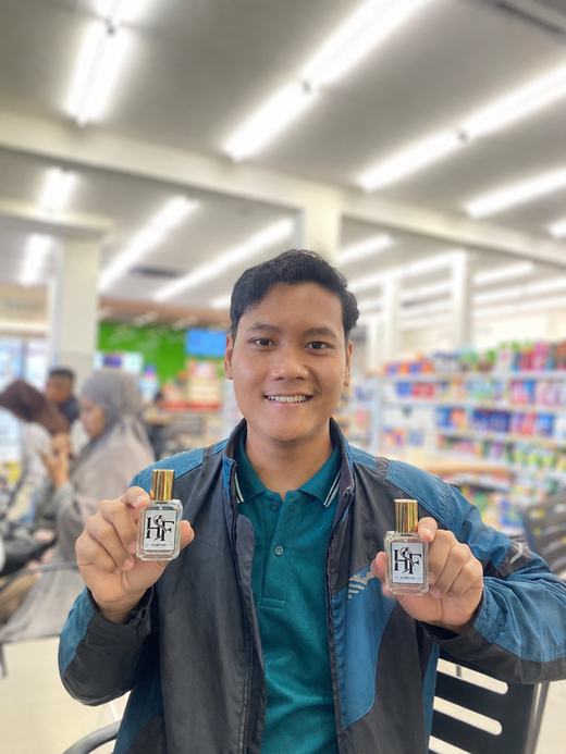 Hafid memegang botol parfum HF Parfume